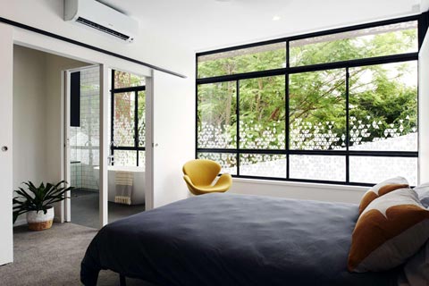 modern, világos hálószoba, nagy ablakkal, franciaágy sötét takaróval, légkondicionáló a falon