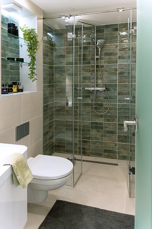 Az apró, mégis kényelmes fürdőben éppen elfért a 160 cm széles, épített zuhanyzó. Színvilágában ugyanaz a türkiz köszön vissza, amit a kárpitokon és párnákon láthatunk