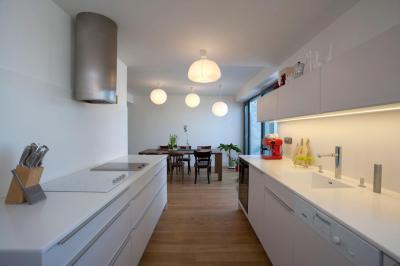 Fehér konyhabútor fapadlóval - konyha / étkező ötlet, modern stílusban