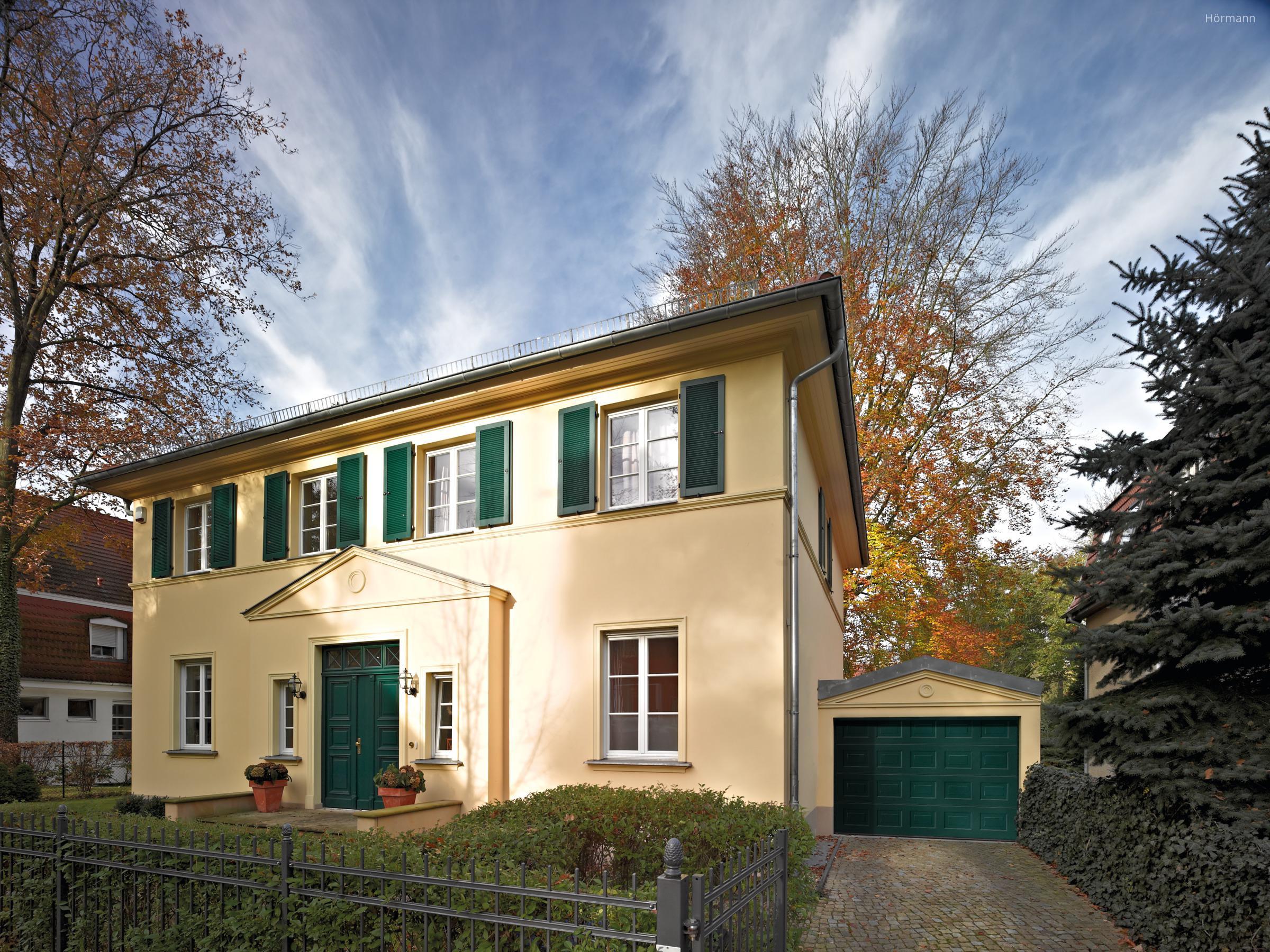 Homlokzathoz illő szekcionált garázskapu - bejárat ötlet